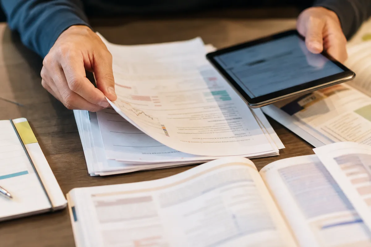 Étudiante comparant plusieurs ressources d&rsquo;apprentissage sur un bureau lumineux